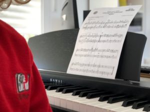 Alumno con partitura al piano en la escuela de música del Colegio el Pinar en Málaga