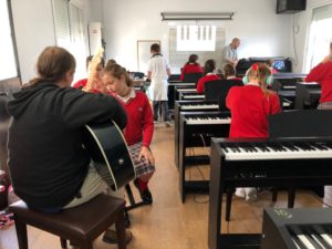 Alumnos tocando las guitarras y pianos en grupo en la escuela de música del Colegio el Pinar en Málaga